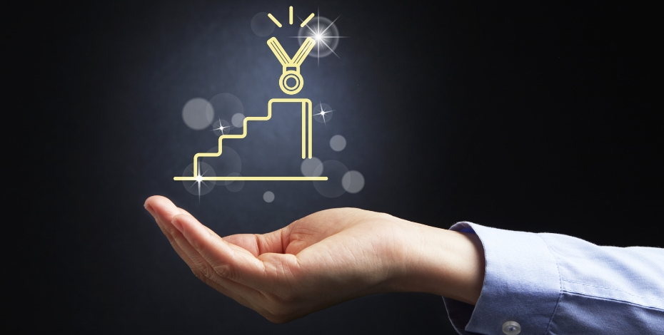 an arm extends from the right side of the image, the palm of the hand is up, hovering above it is a graph with a medal shape on top seemingly in neon lights.