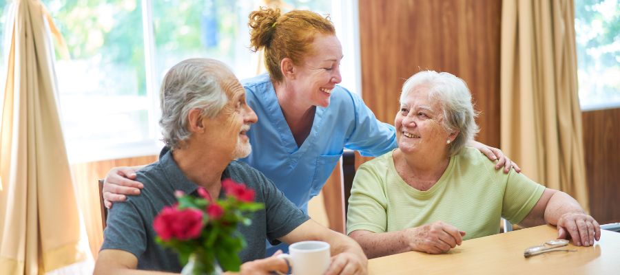 professional with her arms around two older people
