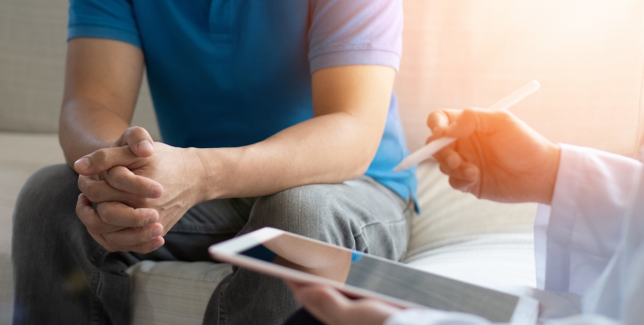 person speaking to a medical professional sitting on a couch