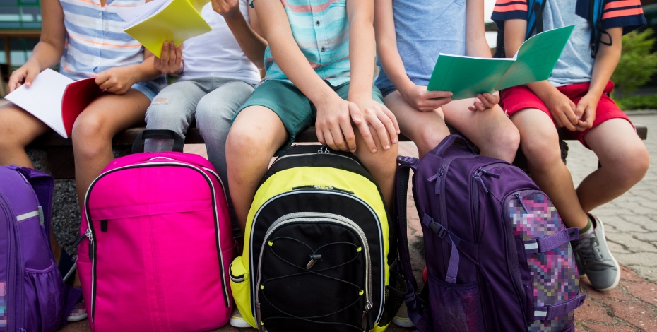 children with backpacks of different colours looking full 