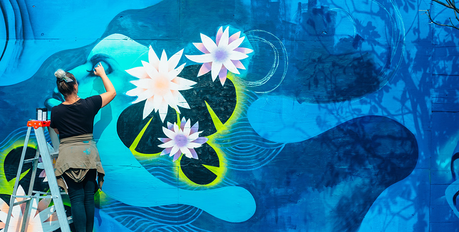 person painting artwork onto a wall